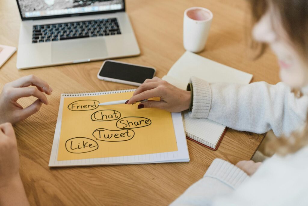 Robot hand writing on a tablet next to a human hand writing on paper, symbolizing AI content writing vs human content for digital marketing