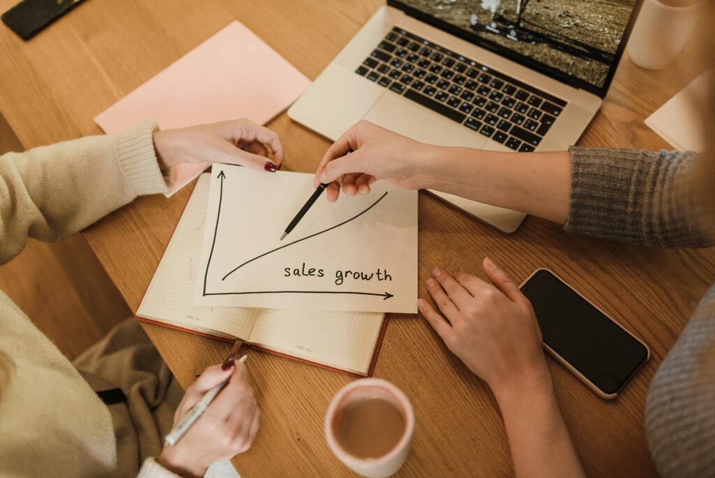 A diverse group of small business owners collaborating on digital marketing strategies on laptops and tablets, symbolizing growth and connectivity.