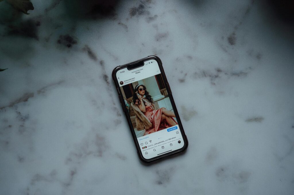 A stylish flat lay of fashion accessories with a smartphone displaying an Instagram feed, symbolizing effective Instagram marketing for fashion brands.