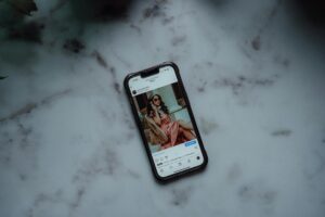 A stylish flat lay of fashion accessories with a smartphone displaying an Instagram feed, symbolizing effective Instagram marketing for fashion brands.