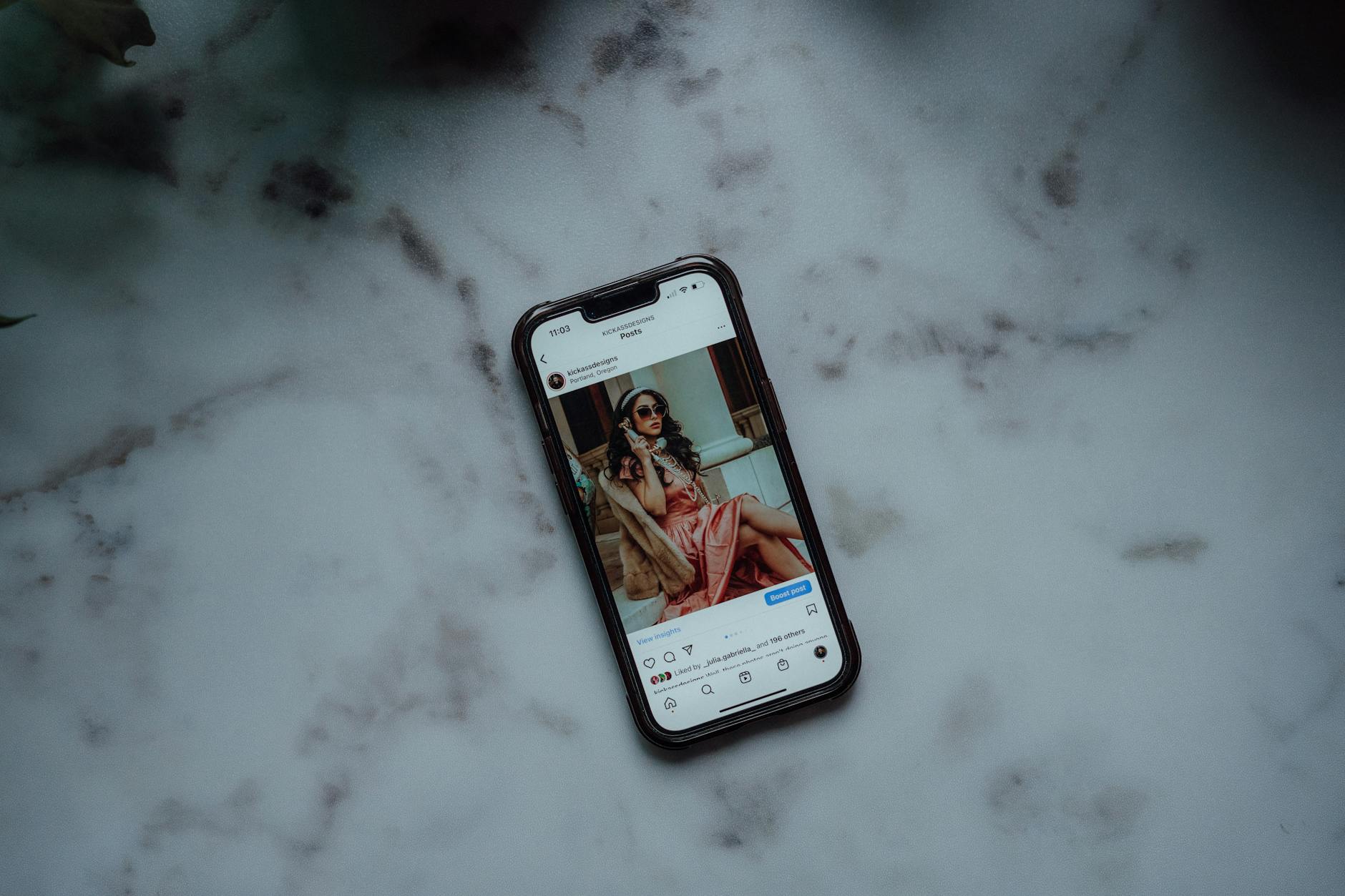 A stylish flat lay of fashion accessories with a smartphone displaying an Instagram feed, symbolizing effective Instagram marketing for fashion brands.